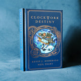 Photograph of a physical hardcover copy of Clockwork Destiny by Kevin J. Anderson and Neil Peart. The angle reveals that the cover has a faux leather texture and copper coloured foil stamping.